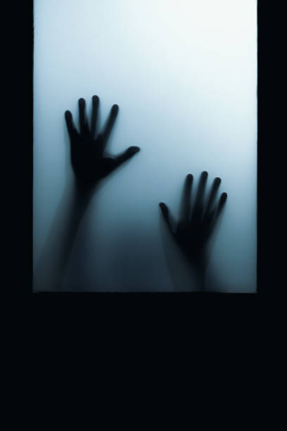 shadow of hand touch behind frosted glass stock photo