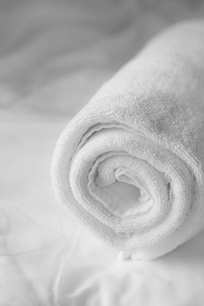 white towel on white bedsheet stock photo
