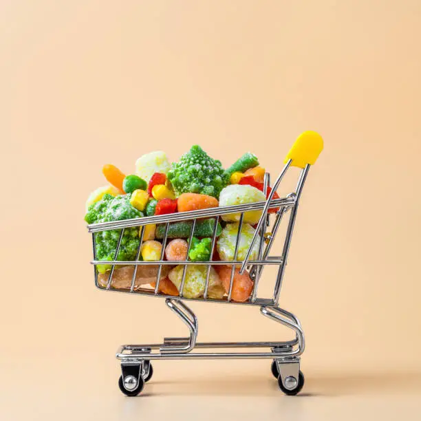 Photo of Frozen vegetables assorted on beige, top view