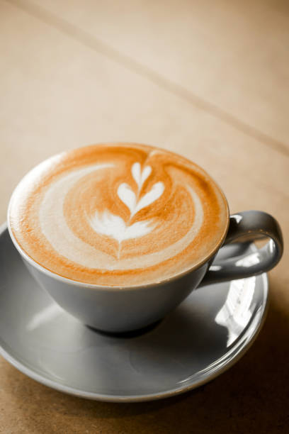 tasse de café avec le modèle de coeur dans une tasse blanche sur le fond en bois - lattã© photos et images de collection