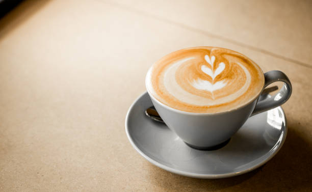 木製の背景に白いカップにハートパターンを持つコーヒーのカップ - lattã© ストックフォトと画像