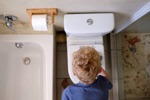 A young boy helps at home by cleaning the bathroom. Young boy does his daily chores in the house during the lockdown