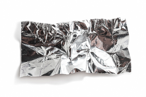 White shiny aluminum foil wrap without chocolate candy on a white background.