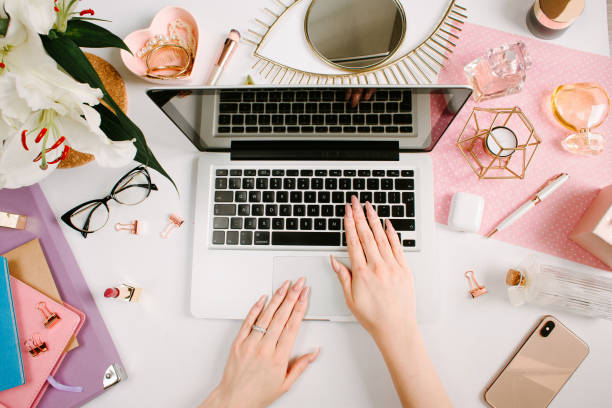 istock Woman work on laptop. Creative desk workspace with computer, clips, flowers, cosmetics, glasses. Flat lay style. Freelance and remote work concept 1221748498