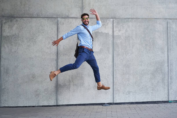 istock Joyful young businessman jumping up and looking at camera 1221749436