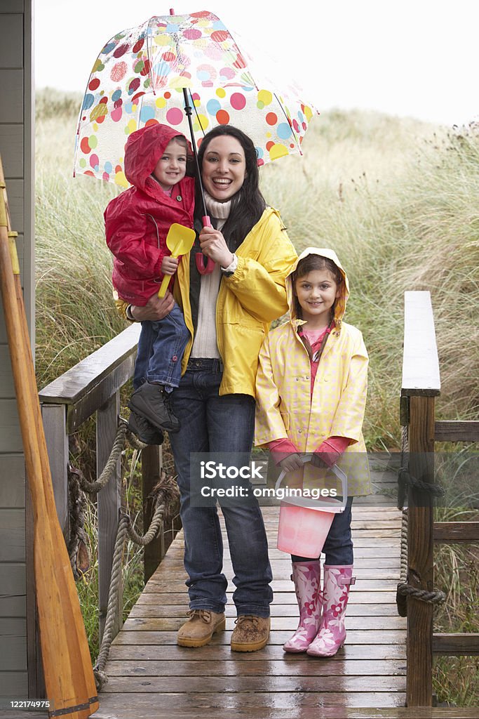 Madre con hijos en la playa de lluvia - Foto de stock de 20 a 29 años libre de derechos