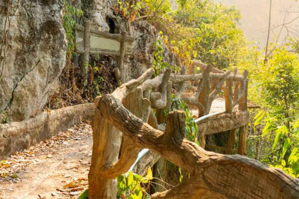 istock Mountain walkway Which has a cement bridge railing in the forest with orange light 1221750540