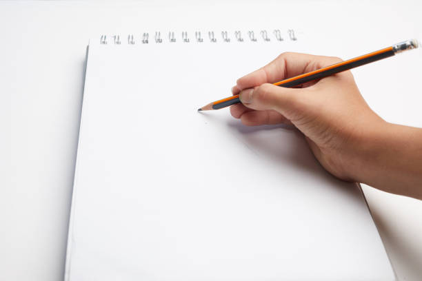 hand holding pen writing on blank white paper background. Hand write in the white blank sheet.