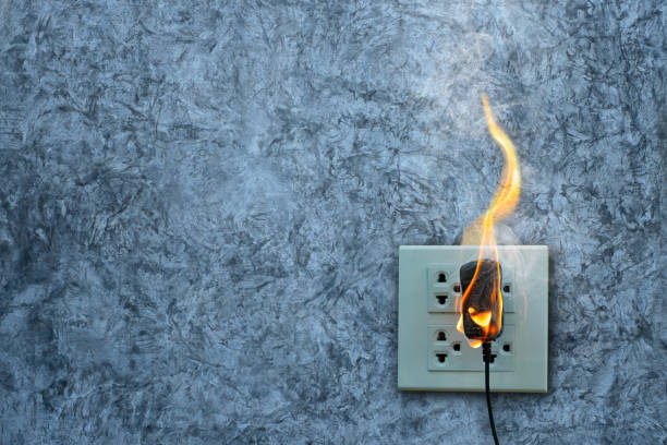 istock On fire charger adapter on the concrete wall exposed concrete background with copy space 1221751740
