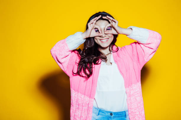 istock girl shows glasses hands on a yellow 1221753588