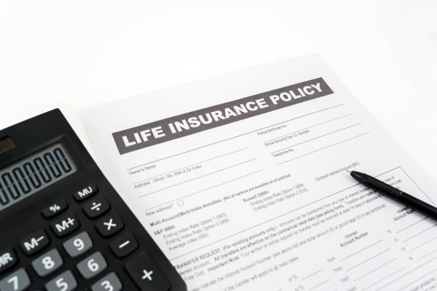 istock Closeup of life insurance document near calculator 1221754343
