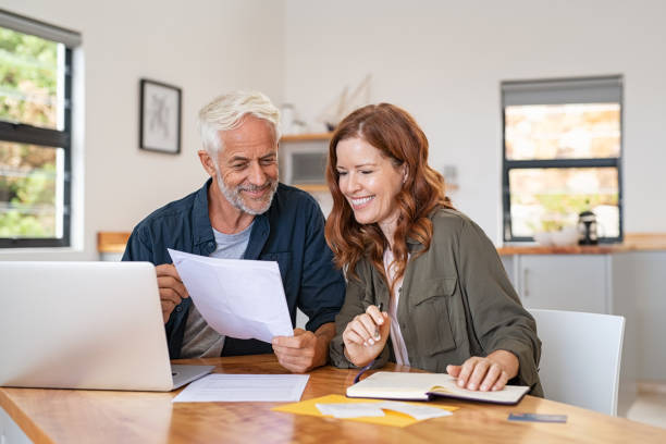 coppia che lavora su laptop - retirement senior adult finance couple foto e immagini stock