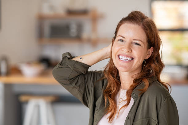 mujer feliz madura riendo - mano en el cabello fotografías e imágenes de stock