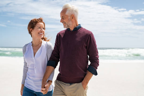 amorevole coppia matura in spiaggia - adult autumn couple face to face foto e immagini stock