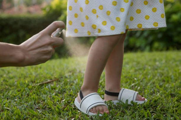 matka stosując komara i robaki odstraszający spray na jej dziewczynkę malucha. - insect repellant zdjęcia i obrazy z banku zdjęć