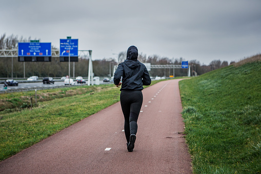 Beautiful Young Female Jogger wearing a sports hijab exercising outdoors in the Netherlands during a training session