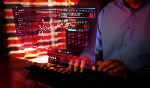 istock Man typing on keyboard with virus detected alert on hologram screen 1221761055