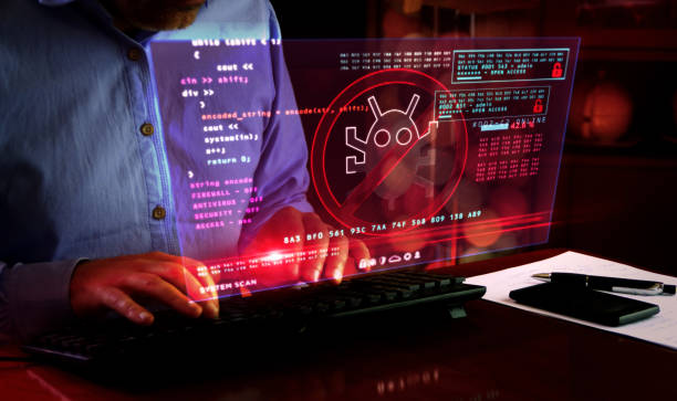 istock Man typing on keyboard with virus detected alert on hologram screen 1221761199