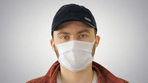 Photo of Young Man Gesturing And Wearing Mask Showing Thumb Up on gradient background