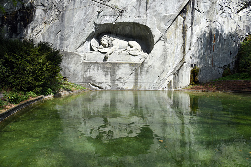 The Lion Monument in Lucerne City is a rock relief, designed by Bertel Thorvaldsen and hewn in 1820–21 by Lukas Ahorn. It commemorates the Swiss Guards who were massacred in 1792 during the French Revolution. The image was captured during the COVID-19_pandemic at springtime.