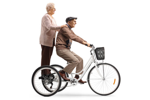 istock Grandparents riding on a tricycle isolated on white background 1221769942