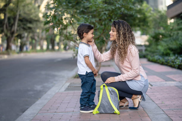 Happy mother taking her son to school