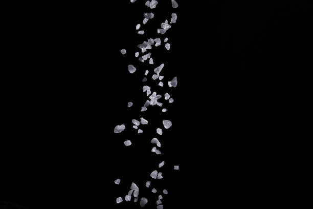 istock Sprinkle salt for seasoning On a black background 1221770800