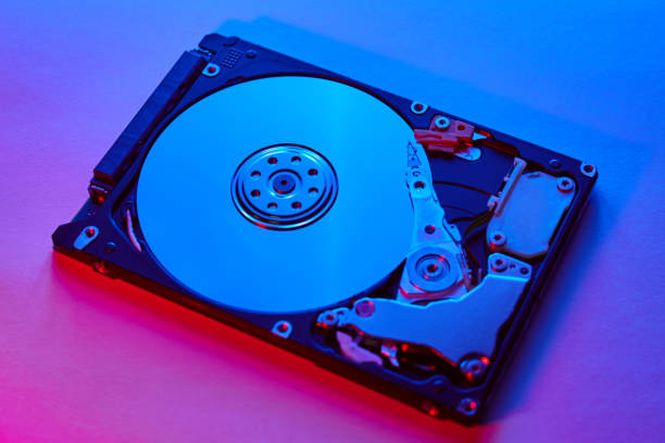 istock Disassembled hard drive from the computer, hdd with neon light. Opened hard drive Part of computer or laptop 1221770816