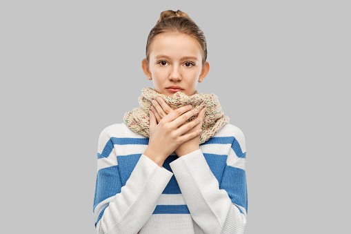 health, medicine and people concept - sad sick teenage girl in scarf over grey background