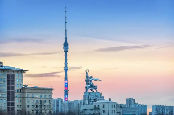 Ostankino Tower and Monument Worker and Collective Farm Girl in Moscow against the sunset sky and residential building