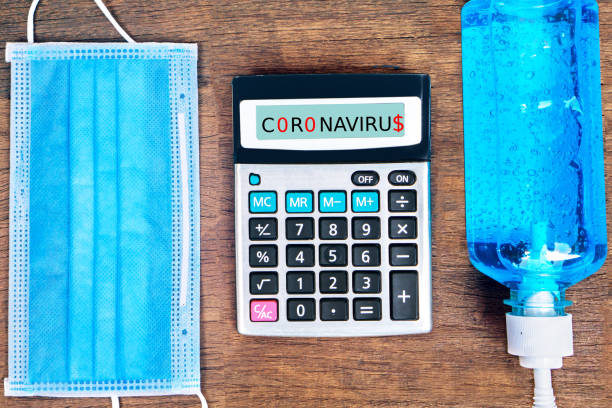 istock coronavirus epidemic, debt and financial problem concept with calculator, protective mask and alcohol gel on desk 1221772662