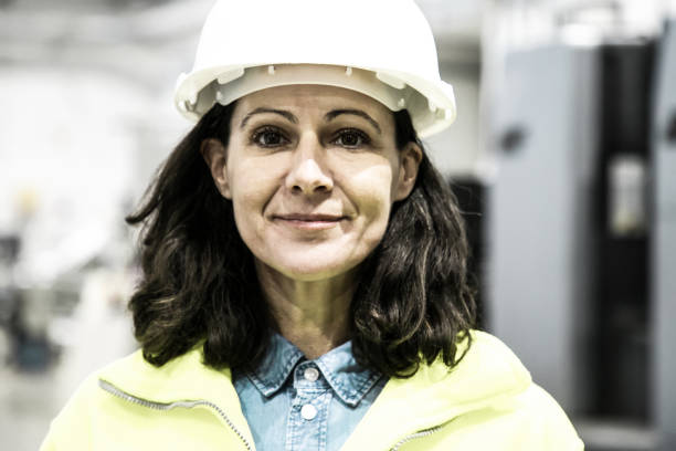 istock Smiling confident female industrial worker posing on plant floor 1221772739
