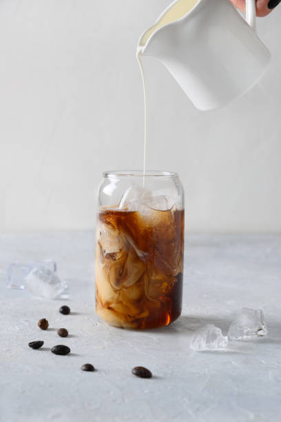 istock Iced latte coffee in glass with pouring milk 1221774797
