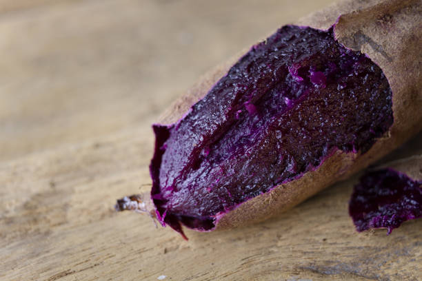 Baked purple color of kapanese sweet potato put on wooden table background