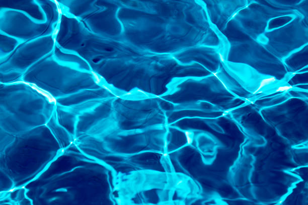 istock ripple water in swimming pool with sun reflection. blue water background texture 1221776754