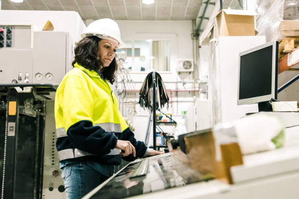 istock Focused female factory worker operating machine 1221777861