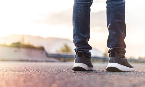 istock Close up hitchhiker legs on highway, journey concept. 1221781158