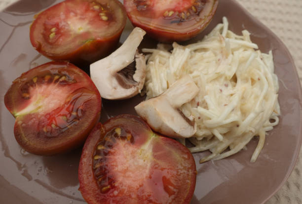 クリミアの黒トマトをセロリ・レムーレード・パリのキノコの前菜の半分にカット - vegetable healthy eating heirloom tomato edible mushroom ストックフォトと画像