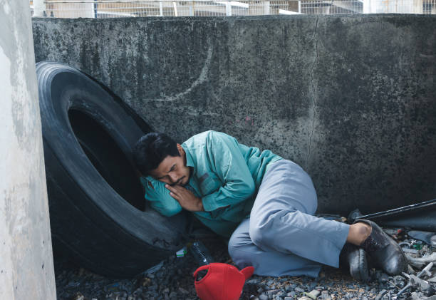 istock Homeless man sitting sadly beside the wall 1221781393