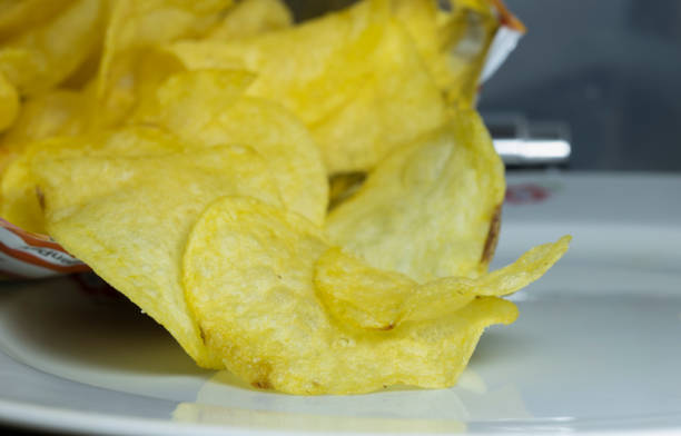 istock Opened chips bag and porcelain plate underneath. 1221781396