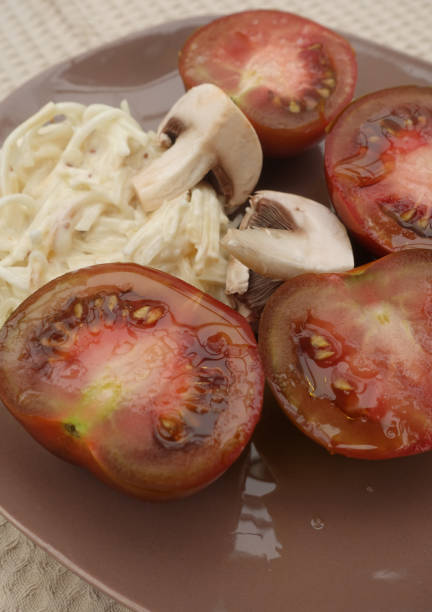krim schwarze tomate geschnitten in der hälfte sellerie remoulade paris pilz vorspeisen - vegetable healthy eating heirloom tomato edible mushroom stock-fotos und bilder