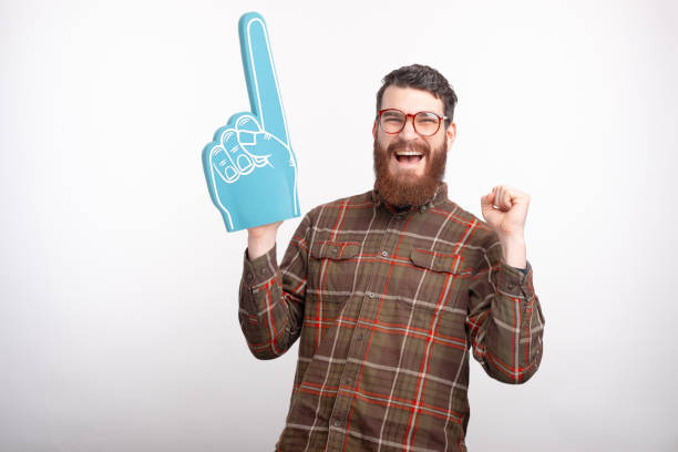 istock Excited man is wearing a blue foam fan glove making winner gesture. 1221782620