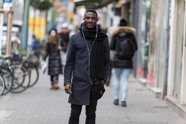 istock Young Black Man with Earphones Posing on Sidewalk 1221782667