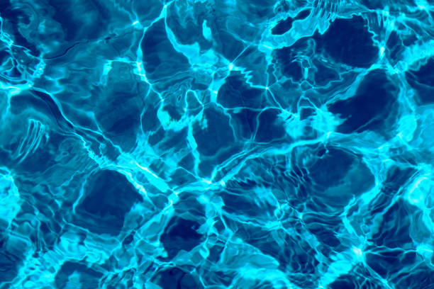 istock ripple water in swimming pool with sun reflection. blue water background texture 1221784207