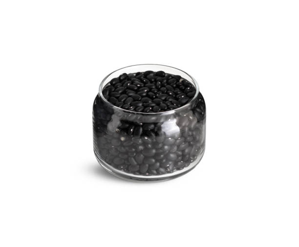 istock Black beans in glass jar on white background 1221787706
