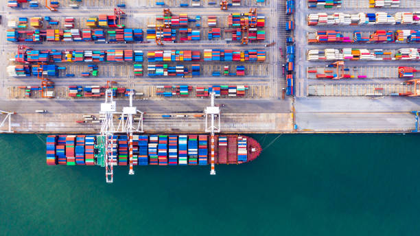 istock Container ship unloading in deep sea port, Global business logistic import export freight shipping transportation oversea worldwide by container ship in open sea, Container vessel loading cargo freight ship. 1221792634