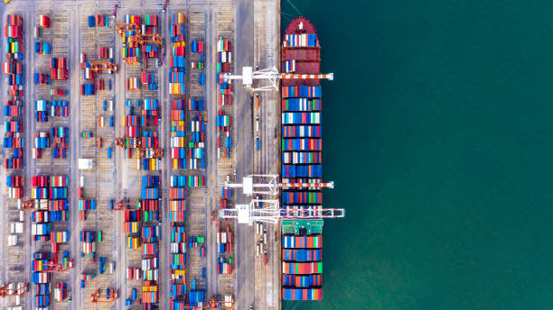 istock Container ship unloading in deep sea port, Global business logistic import export freight shipping transportation oversea worldwide by container ship in open sea, Container vessel loading cargo freight ship. 1221792636