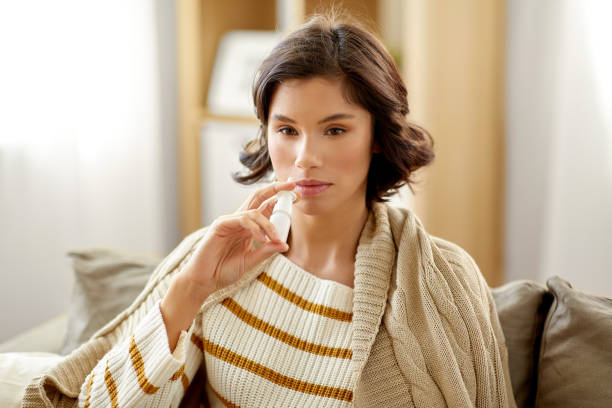 istock sick woman using nasal spray at home 1221792998