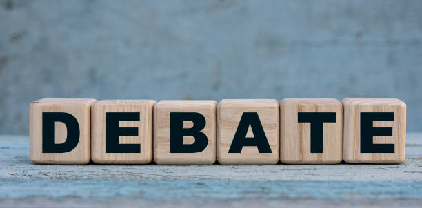 istock DEBATE word on cubes on an old gray background with cactus 1221794080