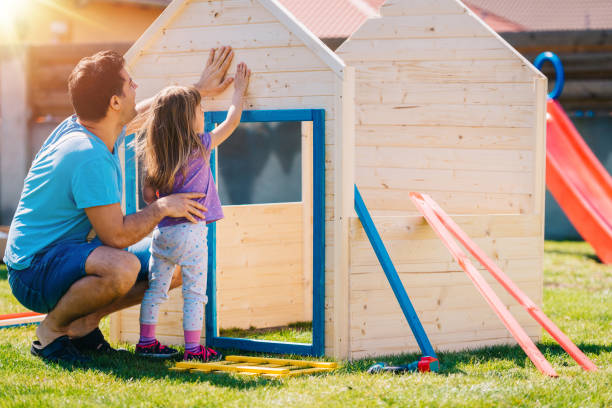 Father and daughter building a wooden house together Father assembling wooden house for his daughter at home playground back yard playhouse stock pictures, royalty-free photos & images